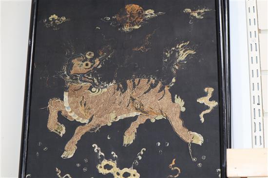 A pair of Chinese/Tibetan embroidered black satin qilin panels, late 19th/early 20th century, 144 x 44cm, worn